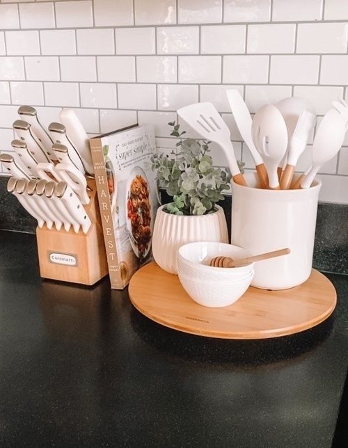 kitchen utensils are arranged on a wooden tray