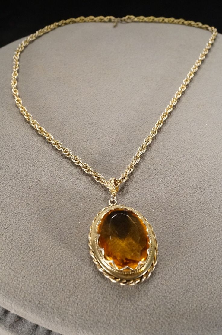 I am offering this beautiful vintage yellow gold tone pendant style necklace. This large oval shaped pendant has a stunning bronze/brown colored glass center stone surrounding a very unique etched exterior. This pendant is measuring app 1.75 inches by app 2.25 inches. The non adjustable detailed chain on this necklace is measuring app 27.5 inches in length. Creamy Caramel, Dangle Necklace, Dangle Necklaces, Brown Art, Oval Pendant, Style Necklace, Gold Jewelry Fashion, Gold Pendant Necklace, Glass Necklace