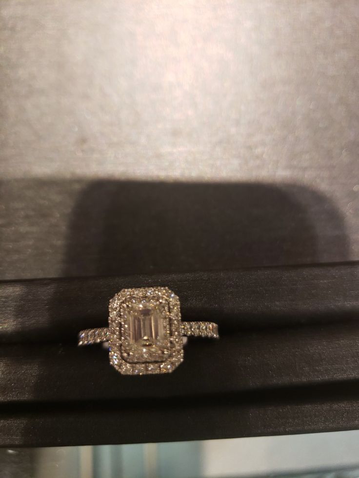 an engagement ring sitting on top of a black box