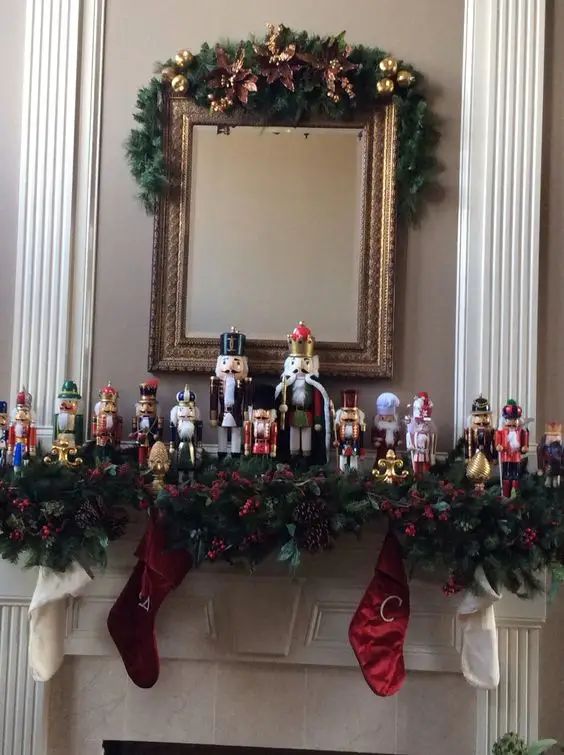 a mantel decorated with christmas decorations and stockings on top of the mantle in front of a mirror