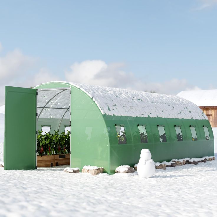 a green building with snow on the ground