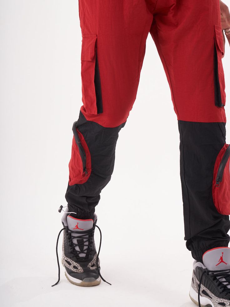 Double-color red and black joggers with four functional cargo pockets on the knees and elastic ankles. FEATURES Slim Fit Made up of 95% Cotton and 5% Elastane Jogger comfort Drawstring waist SIZE GUIDE Model's height and weight: 6"1 feet & 180 lbs. (185 cm & 82 kg ) Model wears size: L Functional Joggers With Cargo Pockets For Outdoor, Functional Joggers With Cargo Pockets For Outdoor Activities, Sporty Joggers With Cargo Pockets For Outdoor Activities, Athleisure Joggers With Cargo Pockets For Outdoor Activities, Sporty Cargo Pants For Hiking, Athleisure Joggers With Cargo Pockets For Outdoor, Sporty Cargo Pants With Side Pockets For Hiking, Functional Joggers With Multiple Pockets For Outdoor, Techwear Cargo Style Joggers For Outdoor