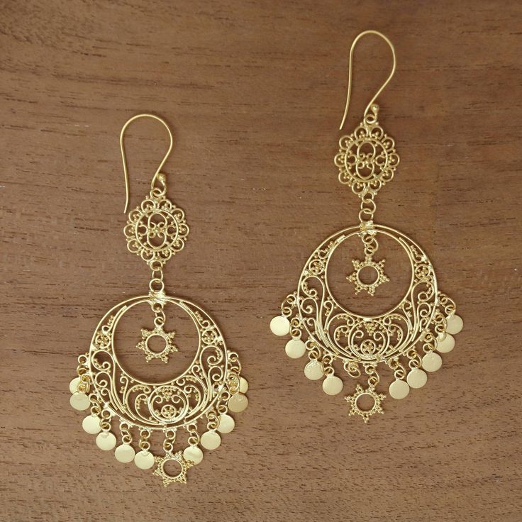 Capturing the beauty of the sunlight these elegant chandelier earrings are designed by Desi Antari in Bali. She works with sterling silver wire and dot patterns to handcraft each earring bathed in 18k gold. A sun shape dangles within each earring which features a sun shape and gleaming medallions that dangle below. Desi Earrings, Dot Patterns, Silver Chandelier Earrings, Gold Jewellry, Silver Chandelier, Fancy Jewellery Designs, Filigree Jewelry, Medallion Pattern, Gem Earrings