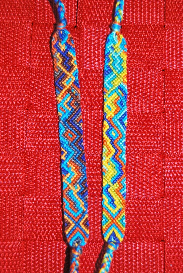 two beads are sitting on a red surface with blue and yellow bead designs in the middle