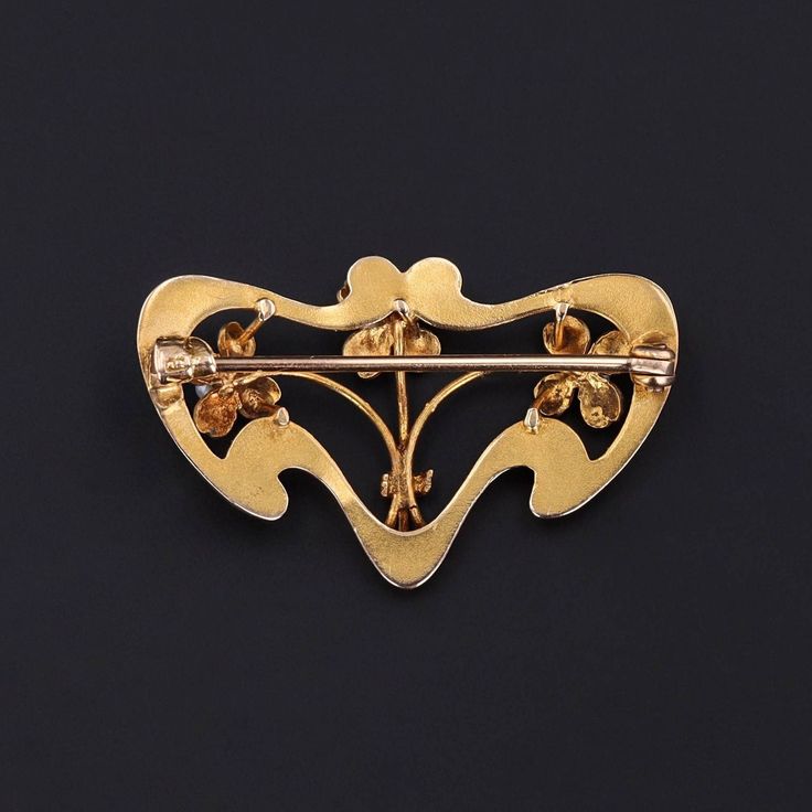 This vintage lucky charm brooch (circa 1910-1920) features three clovers accented with green enamel and pearls. The 10k gold piece measures 0.8 inches by 1.2 inches wide, and it is in great condition. Materials: 10k gold, Enamel, Pearl. Art Deco Yellow Gold Collectible Brooches, Art Nouveau Yellow Gold Brooches Gift, Art Nouveau Yellow Gold Collectible Brooches, Art Nouveau Yellow Gold Brooch Jewelry, Gold Art Nouveau Brooch For Collectors, Art Nouveau Yellow Gold Brooch, Gold Art Nouveau Brooches For Gift, Art Nouveau Gold Brooches As Gift, Art Deco Yellow Gold Hallmarked Brooches