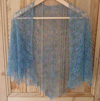 a blue shawl hanging on a wooden wall