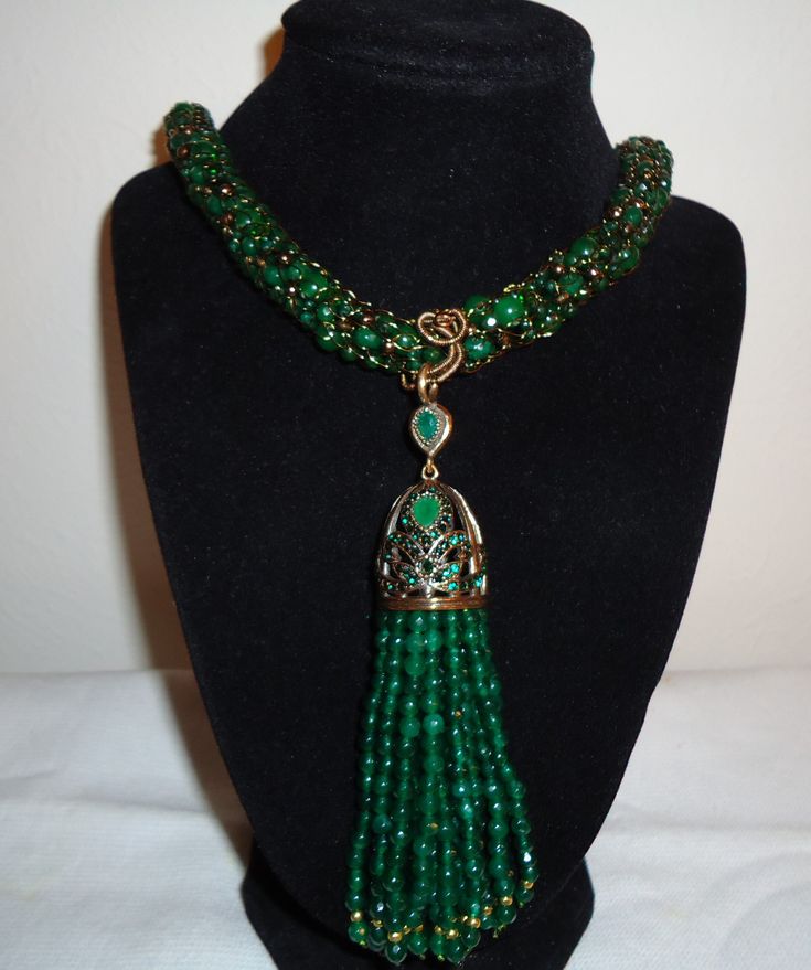 Lovely green jade, green onyx, and gold-colored beads were hand-knitted on vintage gold wire to make this necklace.  This necklace features a tassel pendant made of emerald green jade.  The set includes both the necklace and earrings.  The knitted necklace is 31 inches long, not including the pendant.  The tassel pendant measures 5 inches long and 2 1/2 inches wide.  The matching earrings are made from matching green jade and onyx, and are 2 inches long from the top of the hook.   The knitted necklace can be shortened upon request. Luxury Green Onyx Emerald Necklace, Luxury Green Lariat Necklace, Knitted Necklace, Lubbock Tx, Beaded Tassel Necklace, Multi Layer Necklace, Necklace And Earrings Set, Green Onyx, Gold Wire