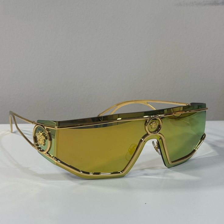 Versace Medusa Gold Tone Mirror Shield Sunglasses Condition: Like New, No Signs Of Wear Includes Designer Case Designer Gold Shield Sunglasses With Gradient Lenses, Luxury Gold Shield Sunglasses With Uva Protection, Luxury Gold Shield Sunglasses With Uv Protection, Gold Mirrored Shield Sunglasses For Parties, Gold Polarized Shield Sunglasses For Party, Gold Shield Sunglasses With Polarized Lenses For Party, Trendy Gold Shield Sunglasses For Formal Occasions, Gold Anti-reflective Glass Sunglasses, Designer Gold Sunglasses With Glass