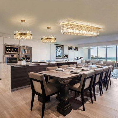 a dining room table with chairs and a chandelier hanging from it's ceiling