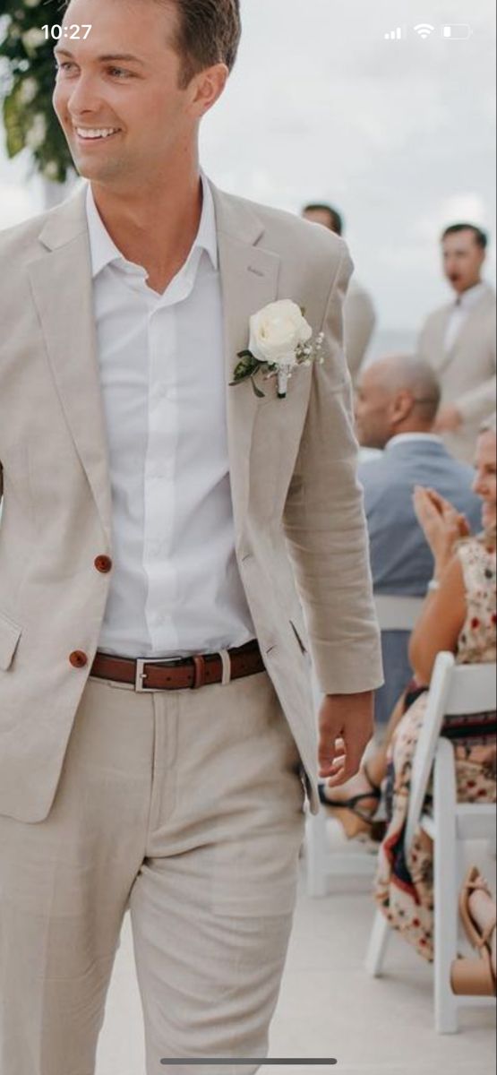 a man in a suit and tie walking down the aisle with his hand in his pocket