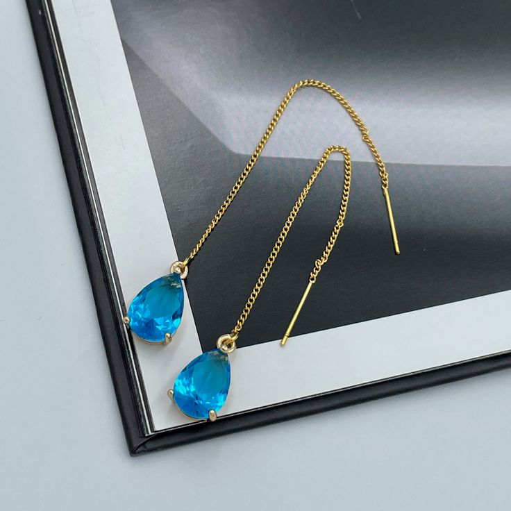 Dainty Blue Thread Earrings, Capri Blue Teardrop Earrings, Statement Blue Drop Earrings, Blue Wedding Earrings, Capri Blue Thread Earrings. These are simple and beautiful teardrop crystal earrings. Blue crystals are framed in bright gold and dangling from long thread. Measurements: The total length from the top of the hook to bottom - 3.74 inches (95 mm) approximately. Crystals: 12 mm x 8 mm The earrings would be a PERFECT GIFT for you and your family and friends! Click here to see more Modern E Blue Dangle Teardrop Earrings For Pierced Ears, Blue Teardrop Dangle Earrings, Blue Teardrop Crystal Earrings For Pierced Ears, Blue Drop Crystal Earrings For Party, Blue Long Drop Teardrop Earrings For Pierced Ears, Single Blue Teardrop Earring, Blue Long Drop Teardrop Earrings, Blue Teardrop Crystal Earrings, Blue Long Drop Teardrop Earrings Gift