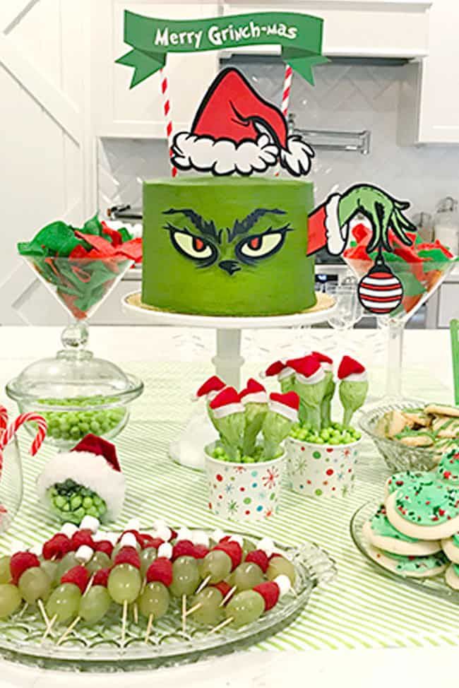 a table topped with lots of desserts covered in green frosting