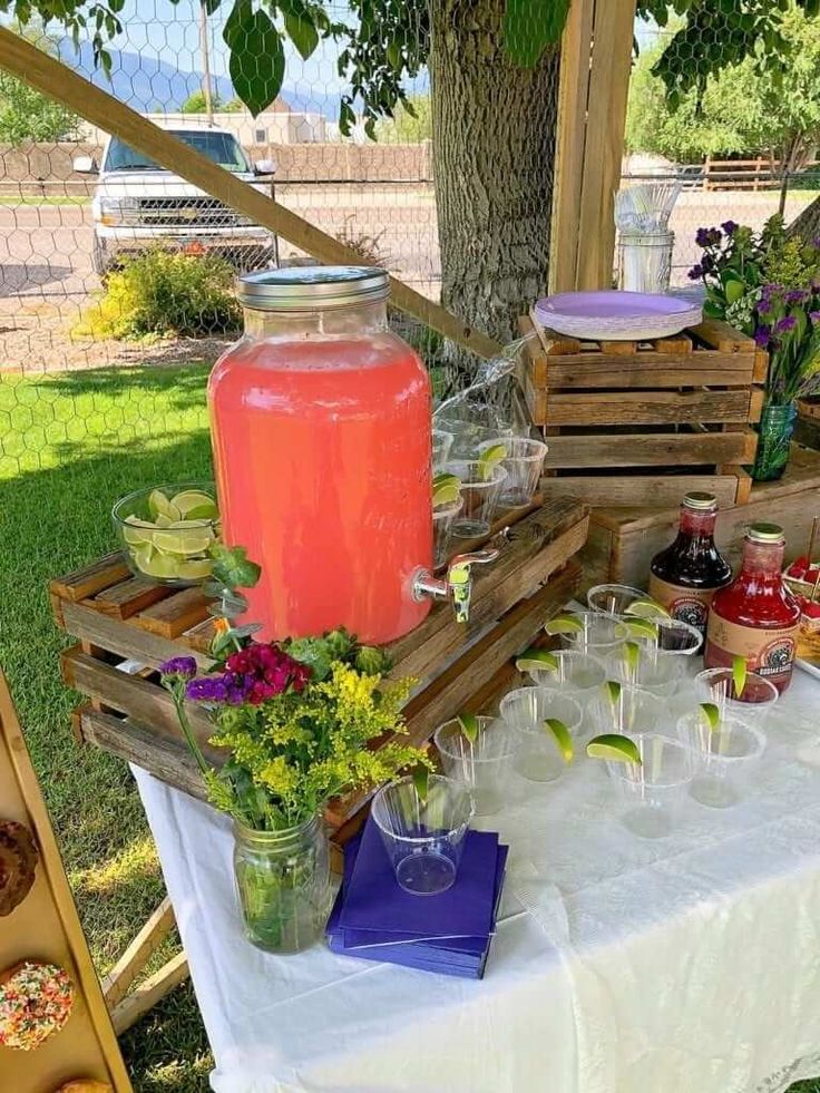 a table topped with glasses filled with drinks and desserts next to a wooden crate