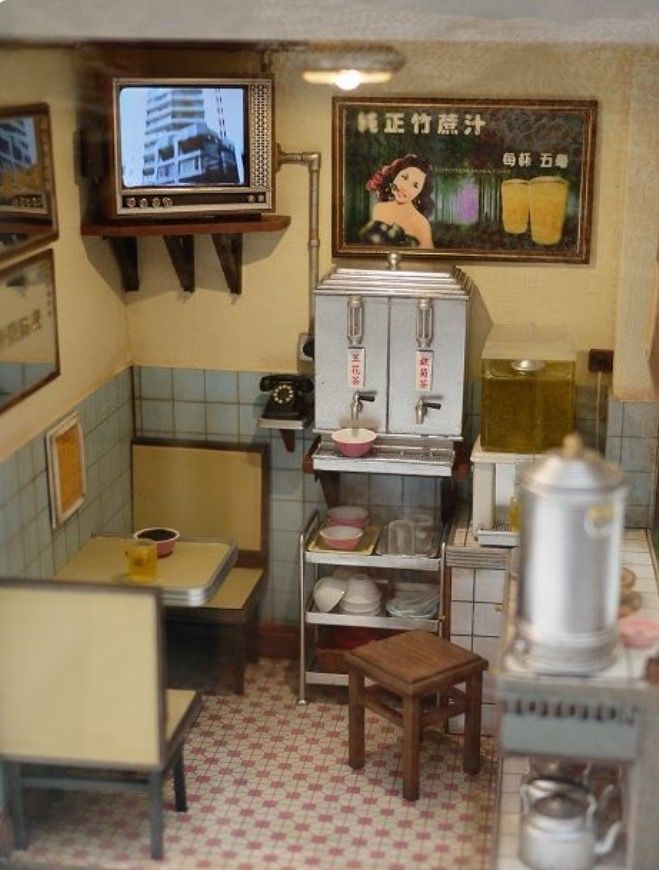 a doll house kitchen with an old fashioned stove and microwave in the corner, next to a small dining table