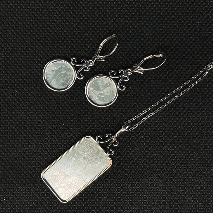 This pretty pendant / enhancer features an antique mother-of-pearl gaming counter that has been bezel set in 14k white gold. Gaming counters, or "chips" such as this one were originally carved in China for export to Britain, where they were used the way we use poker chips. This particularly fine-quality chip has beautiful pearlescent luster and is intricately carved. The pendant is simple in design, yet elegant in appearance, and can be dressed up by clipping the bail over a strand of pearls! Wh Classic White Jewelry With Rectangular Pendant, Polished Mother Of Pearl Pendant Jewelry, Vintage Carved White Gold Jewelry, Etched Medallion Jewelry In White Gold, White Gold Etched Medallion Jewelry, Etched White Gold Medallion Jewelry, Elegant Engraved Mother Of Pearl Jewelry, Elegant Engraved Mother Of Pearl Necklace, Elegant Engraved Jewelry For Collectibles