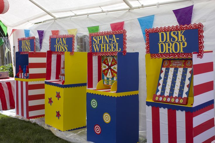 several carnival booths are lined up on the grass