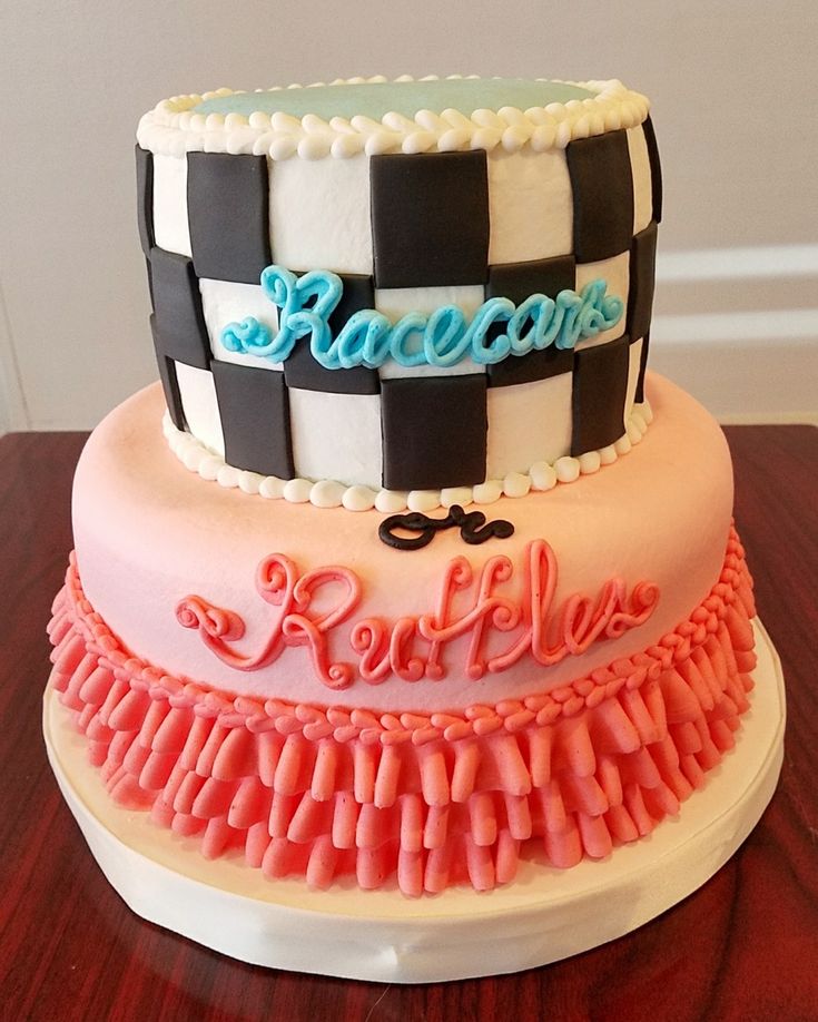 a three tiered cake with pink, blue and black icing