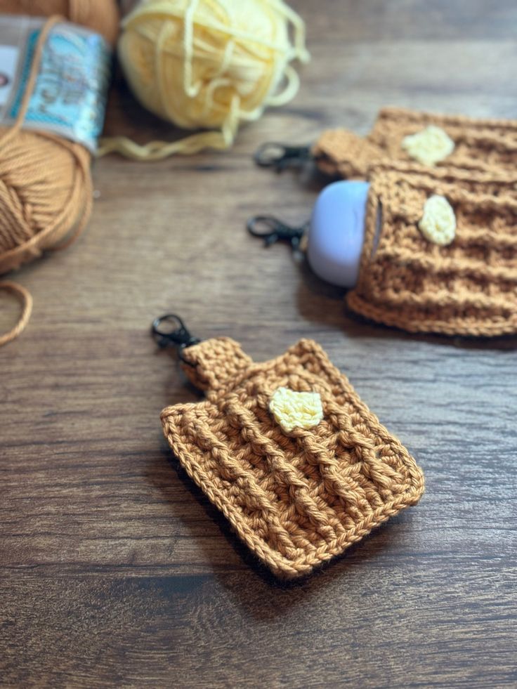 three crocheted items sitting on top of a wooden table