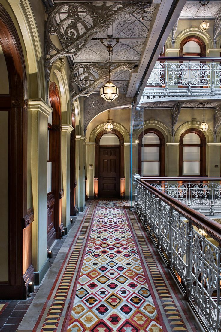 an ornate hallway in a building with many windows and balconies on the ceiling