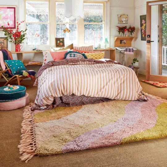 a bed room with a neatly made bed and lots of pillows