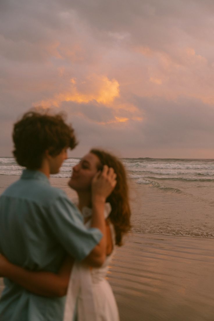 a man and woman are standing on the beach