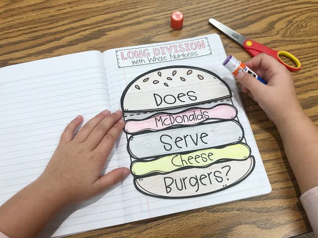 a child's hand writing on a notebook with hamburgers