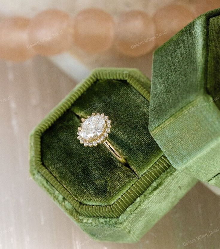 an engagement ring in a green velvet box