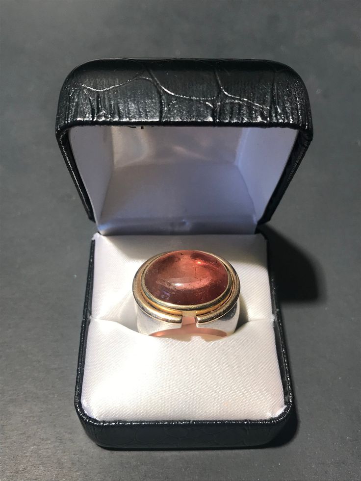 Beautiful custom made Pink Champagne Tourmaline Stone, with 18k gold and sterling silver ring. Very substantial one of one piece- a show stopper. We purchased this piece as part of a jewelry collection in London, UK. Origin: London, UK Period: 1970 - 1979 Condition: Good, not brand new or in flawless condition- there is wear to the metals and stone. A choice piece. US Ring Size: US 8 * Complimentary shipping to Continental US. * Our Guarantee: Items purchased online will arrive as described. Polished Tourmaline Ring As Gift, Polished Tourmaline Rings For Gift, Unique Cabochon Ruby Ring For Formal Occasions, Formal Heirloom Tourmaline Jewelry, Formal Hallmarked Tourmaline Jewelry, Luxury Polished Tourmaline Rings, Silver Tourmaline Rings For Formal Occasions, One Of One, Tourmaline Stone