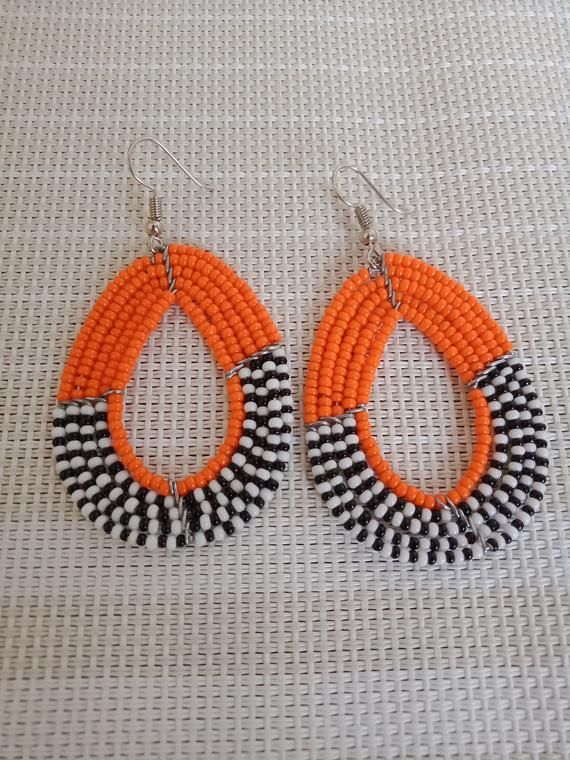 Circle Earrings | Custom Earrings | Hoop Earrings | Dainty Earrings | Beaded Earrings | Moms Gift | Gift Ideas | Unique Gift These eye catching  earrings are superbly crafted and can be worn with any outfit.The earrings are very light to wear.Main Color - Orange.The earrings can be available in different colors.(Please choose color as you check out)The earrings measure 3 inches from top of the hook.**Buy multiple items and pay shipping for 1 item only.The rest ships free.Feel free to send me a c Handmade Orange Jewelry With Oval Beads, Orange Hoop Beaded Earrings As Gift, Orange Beaded Round Earrings, Handmade Orange Hoop Earrings, Orange Beaded Hoop Earrings, Handmade Orange Earrings With Round Beads, African Woven Basket, African Beads Necklace, Pony Bead Crafts