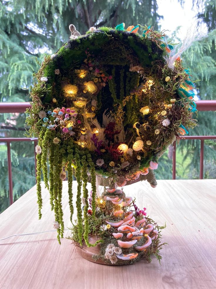 an arrangement of plants and donuts is displayed on a wooden table with trees in the background