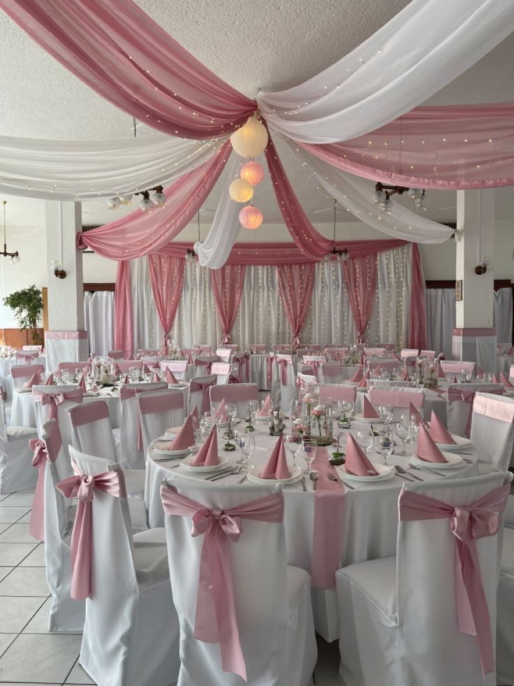 the tables are set with white and pink linens for a wedding or special event