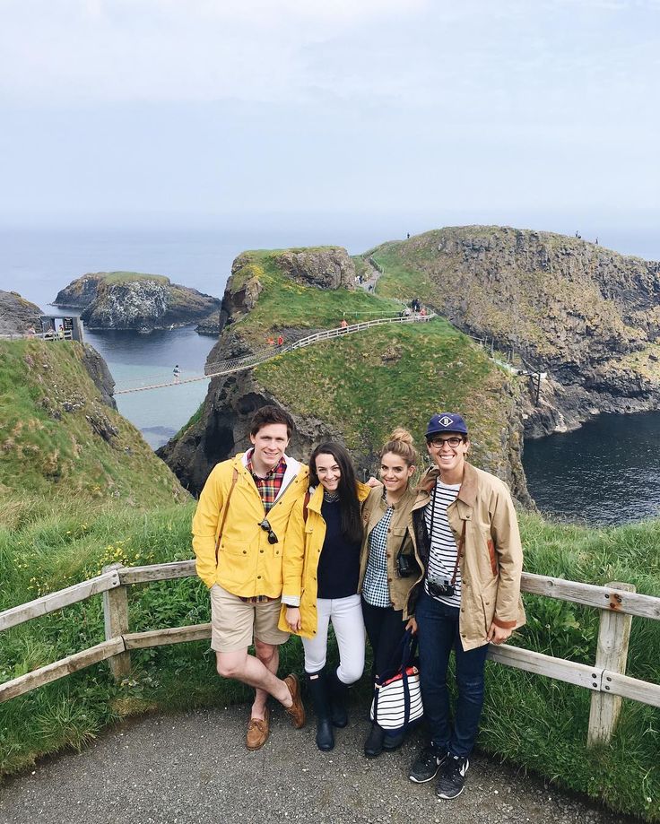 three people are posing for a photo in front of some cliffs and the ocean on their cell phone