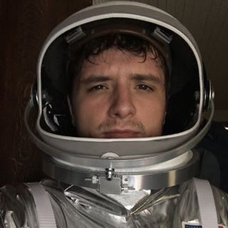 a man wearing an astronaut's suit and helmet