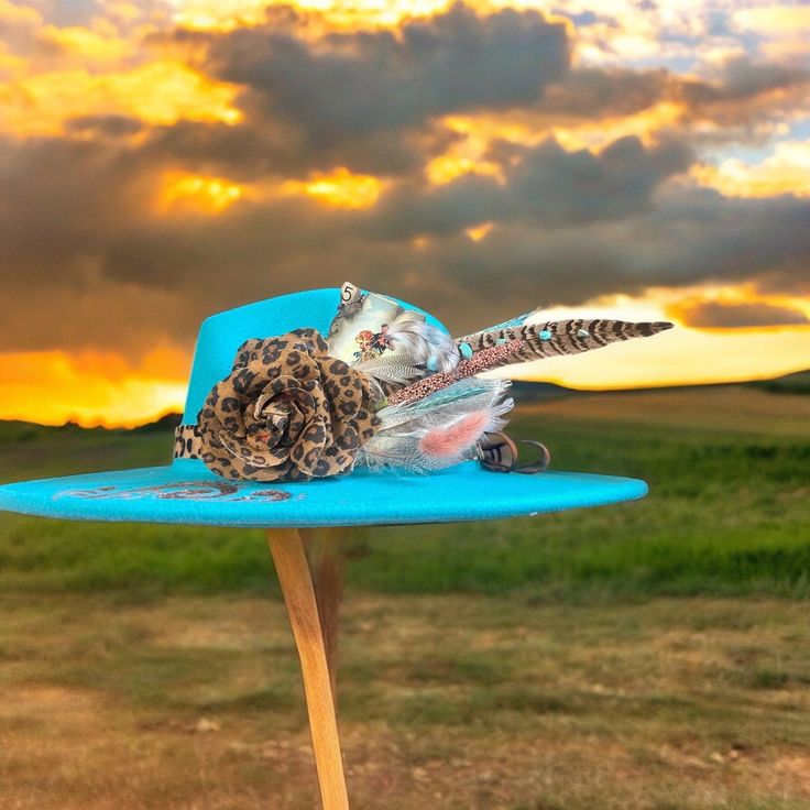 Clip on hat fascinator with western card, feather turquoise and leopard flower. Clips into most hatbands. Hat not included. Turquoise Hat For Summer Western-themed Events, Blue Fedora For Kentucky Derby And Country Events, Kentucky Derby Fedora Mini Hats With Feathers, Turquoise Wide Brim Hat For Kentucky Derby, Turquoise Hat For Kentucky Derby Festival, Turquoise Hat For Kentucky Derby And Country Events, Turquoise Hats For Kentucky Derby And Festivals, Turquoise Hat For Kentucky Derby, Turquoise Hat For Festival And Kentucky Derby