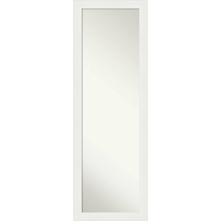 a white door with a mirror on the front and bottom panel, in an empty room