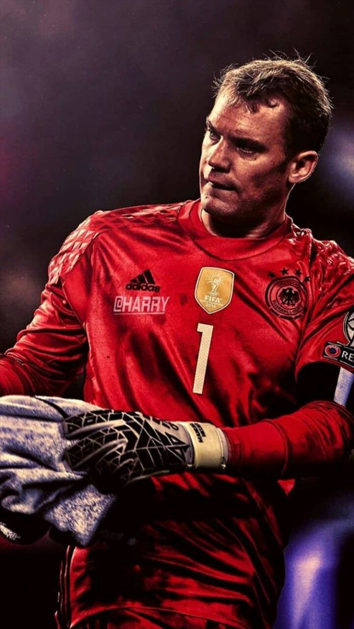 a man in red jersey holding a soccer ball and glove on his left hand while wearing black gloves