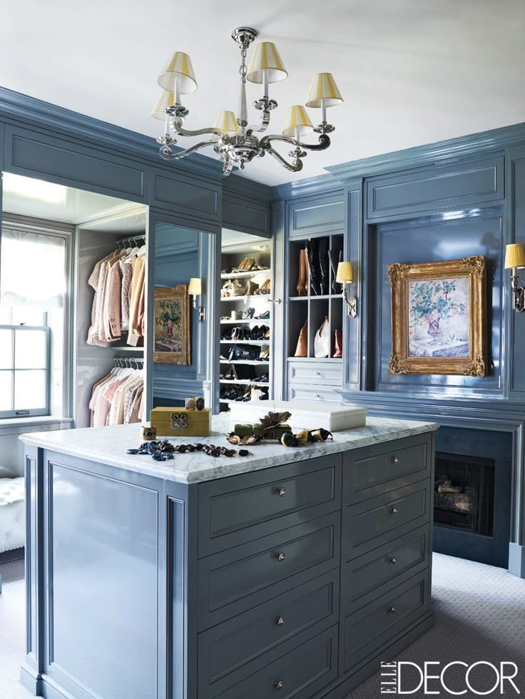 a room with blue cabinets and a chandelier