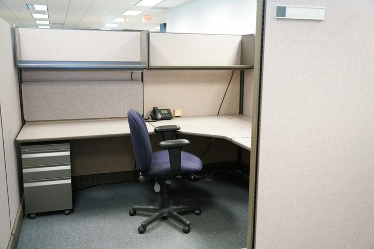 an office cubicle with a chair and desk