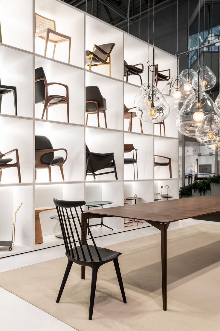 a table and chairs in front of a wall with hanging light bulbs on the ceiling