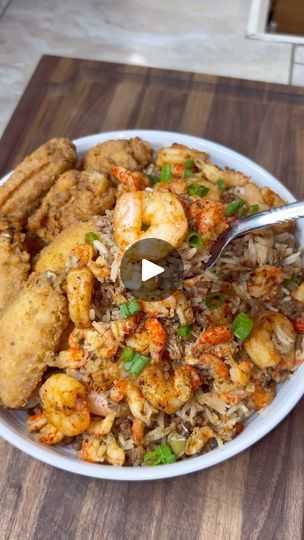 a white bowl filled with fried shrimp and rice on top of a wooden cutting board