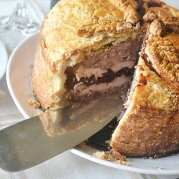 a large piece of meat on a plate with a knife