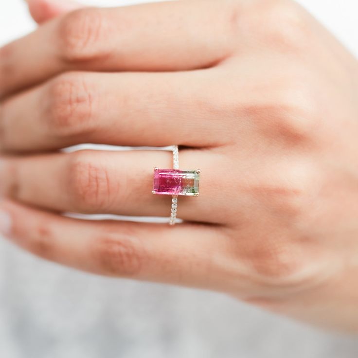 a woman's hand wearing a ring with a pink tourmaline in it