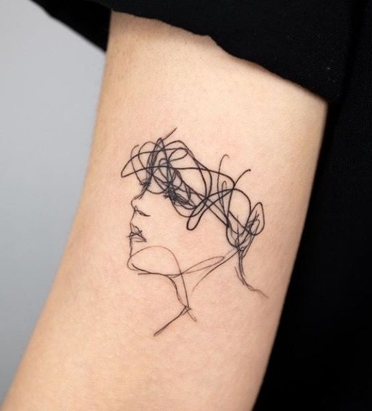 a woman's arm with a black and white line work tattoo on the left inner arm