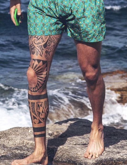 a man standing on top of a rock next to the ocean holding a green frisbee