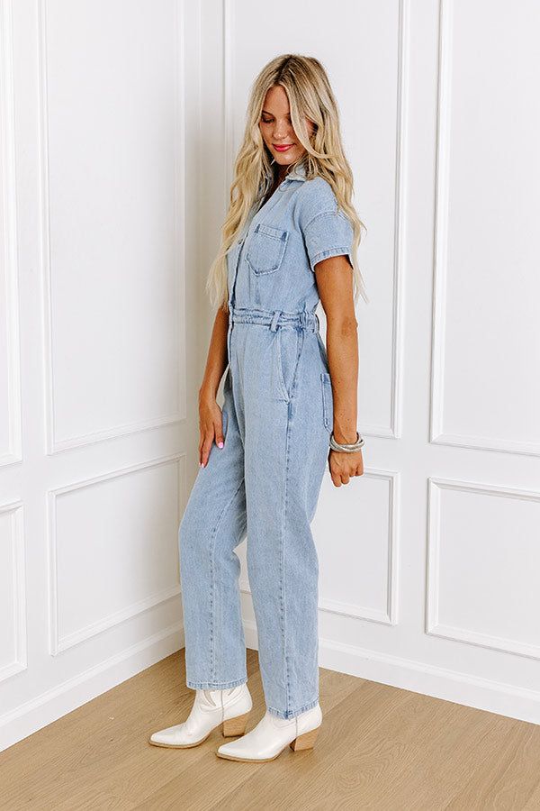 Jump into trendy style with this denim jumpsuit! Unlined denim material - A collared v-cut neckline that goes into a button-up bodice - Short sleeves - A functional chest pocket - A waistline with an elastic back, belt loops, a hidden zip fly, and button closure - Functional side and back pockets - A relaxed silhouette that ends in ankle length hemlines Light Wash Button-up Denim Jumpsuit, Chic Light Wash Cotton Jumpsuits And Rompers, Chic Medium Wash Cotton Denim Jumpsuit, Spring Medium Wash Denim Jumpsuits And Rompers, Trendy Light Wash Overall Jumpsuits, Denim High-rise Jumpsuits And Rompers With Pockets, High Rise Denim Jumpsuits And Rompers With Pockets, Light Wash Button-up Jumpsuit Or Romper, Denim Jumpsuits And Rompers With Pockets And High Rise