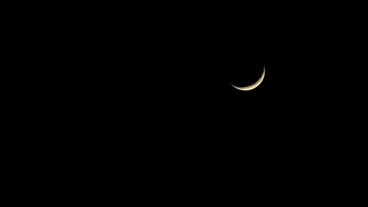 the moon is seen in the dark sky with only one light on it's side