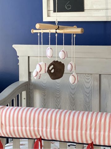 a baby crib with a teddy bear mobile hanging from it's side