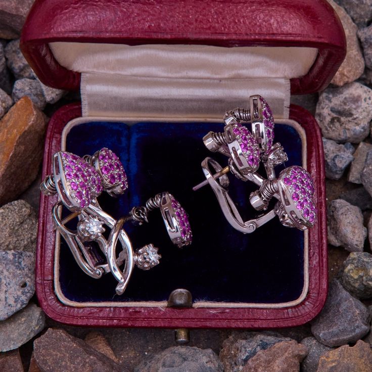 This fantastic pair of en tremblant earrings each feature three heart shaped cluster settings accented with seventy-three (73) round cut natural pink sapphires, and two (2) prong set round brilliant cut diamonds. The hearts settings are attached to springs that allow them to move. The earrings measure 28mm X 27mm and are finished with hinged backs for pierced ears. Luxury Pink Sapphire Earrings For Formal Occasions, Elegant Pink Sapphire Earrings For Wedding, Wedding Pink Sapphire Earrings, Elegant Pink Sapphire Earrings With Prong Setting, Luxury Pink Sapphire Earrings As Gift, Luxury Pink Sapphire Earrings For Gift, Pink Cluster Jewelry With Diamond Accents, Elegant Pink Sapphire Earrings For Anniversary, Fine Jewelry Platinum Cluster Earrings As Gift