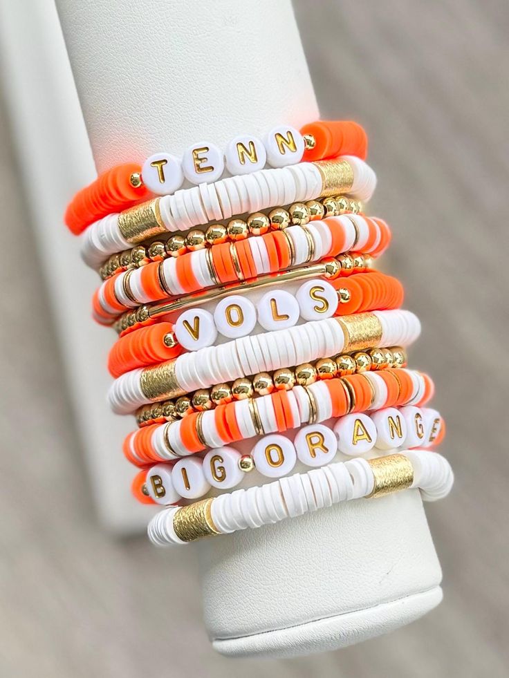 UNIVERSITY OF TENNESSEE stackable friendship bracelets. Perfect for game days or every day!  Bracelets are made with Heishi (clay) beads, 18k gold filled spacer beads, & gold plated brass spacer and barrel beads.   Each bracelet sold separately*  INSTRUCTIONS: 1. Measure your wrist and select size from drop down menu. (See photo for measurement instructions.) 2. Select which bracelet(s) you want to purchase from the "BRACELET OPTIONS" drop down menu.  3. Complete the "PERSONALIZATION" Section if you would like to make any changes.  📦📫FREE SHIPPING ON ALL DOMESTIC ORDERS OF $35 OR MORE! 📌Care:  Keep bracelets dry and away from chemicals. Roll bracelet on instead of stretching over hand. Bracelets may break with excessive over-stretching. 📌Since each bracelet is made to order, all sales School Spirit Beaded Bracelets, Football Team Clay Bead Bracelets, College Bracelet Stacks, Tennessee Clay Bead Bracelets, Stack Bracelets Beaded, Team Bracelets, Keep Bracelet, Stacked Beaded Bracelets, Bracelets Handmade Diy