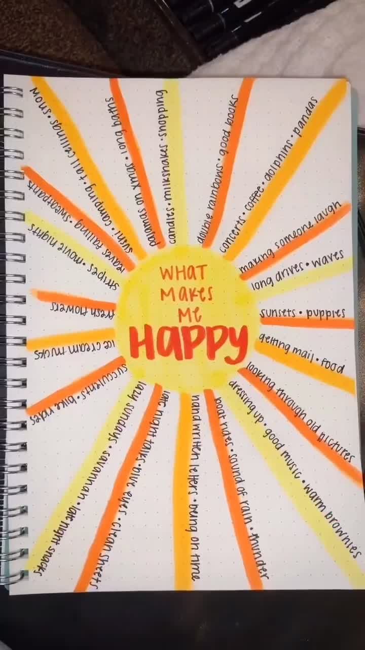 a spiral notebook with the words what makes me happy written in orange and yellow on it